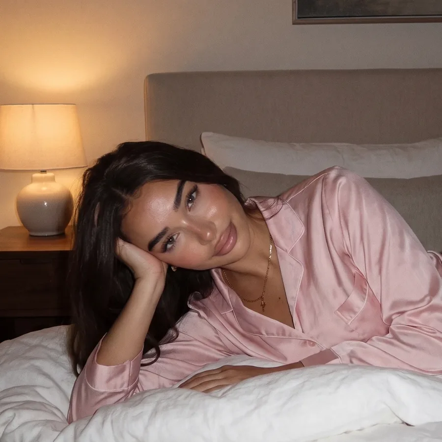 Leina in pink satin pajamas by the bedside lamp, the private side